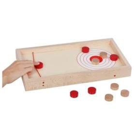 Une main tend l'élastique pour lancer un palet rouge vers la cible du curling