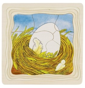 Puzzle du cycle de vie de la poule monté, l'œuf blanc dans son nid de paille