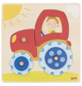 Puzzle tracteur Goki assemblé, capot et cabine rouges, roues à engrenages bleues sur plateau clair